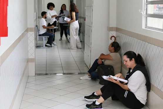 Candidatos de um exame nacional encontram-se em um corredor