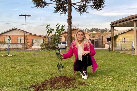 Servidora planta árvore no pátio da comarca de Correia Pinto. 