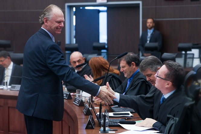 Foto colorida: autoridades cumprimentando‑se no plenário judicial, ambiente institucional interno, sessão solene, formalizando atos