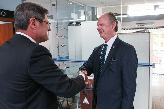 Presidente do TJ Rubens Schulz cumprimentando o juiz Rudson Marcos, ambos estão  sorrindo.
