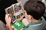 Foto de uma criança lendo a revista Aventuras na Justiça