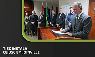 Banner com foto do presidente assinando o termo de instalação do CEJUSC