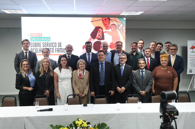 Foto colorida: grupo em frente à mesa diretiva, plenário institucional interno, curso de formação, registrando encerramento 