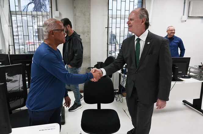 Foto horizontal: desembargador Rubens Schulz cumprimenta servidor durante visita institucional a unidade administrativa do TJSC.