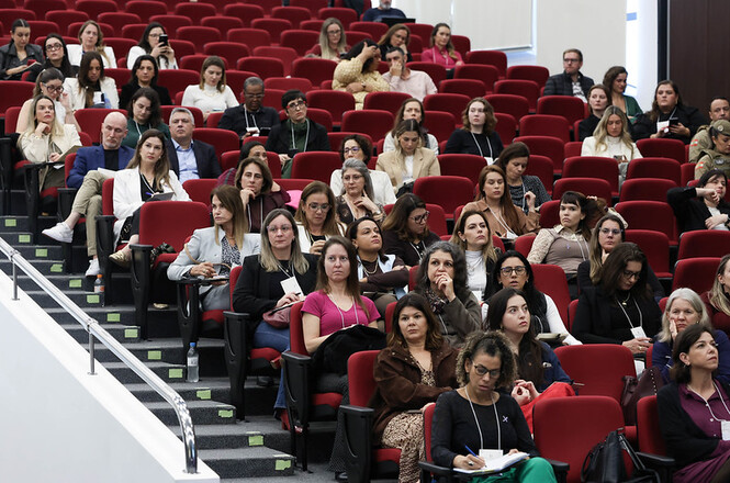Foto horizontal: Público acompanha as palestras e debates durante seminário em auditório sobre os 20 anos da Lei Maria da Penha.