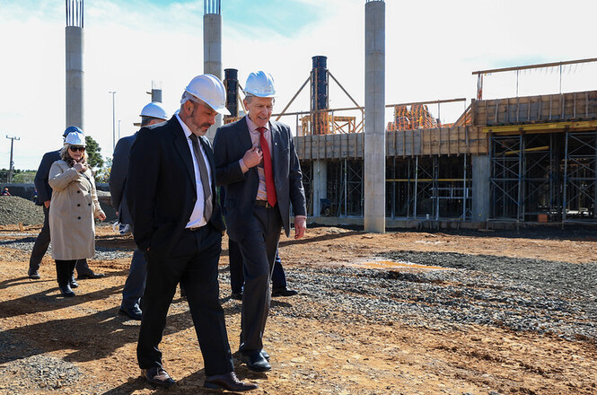 Foto horizontal: pres. do TJSC, des. André Luiz Dacol, ouve atentamente autoridade durante visita ao canteiro de obras.