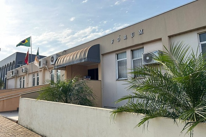 Foto horizontal: fachada do Fórum da comarca de Abelardo Luz, com rampa de acessibilidade, entrada principal e bandeiras.