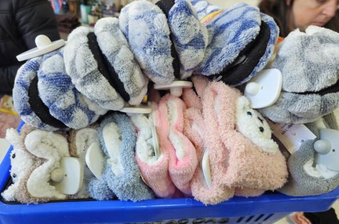 Cesto reúne meias e pantufas arrecadadas para campanha solidária de inverno.