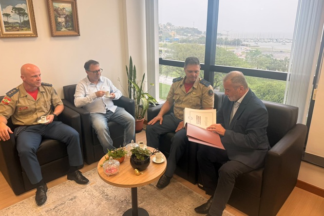Foto horizontal: desembargador Altamiro de Oliveira recebe documento de integrante do Corpo de Bombeiros durante encontro no TJSC.