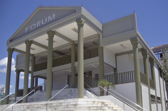 Foto horizontal: fachada do Fórum da Comarca de Balneário Camboriú, com colunas, escadaria e céu azul ao fundo.