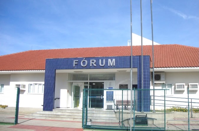 Foto horizontal: fachada do fórum de Balneário Piçarras, prédio institucional em destaque, ambiente externo, clima de acesso à Justiça.
