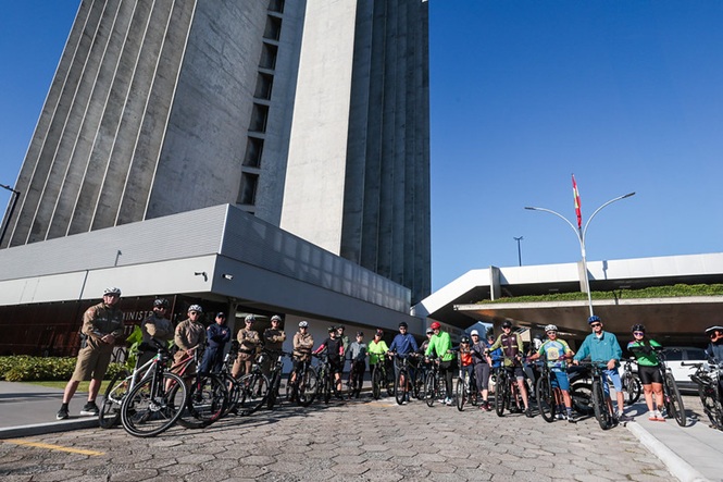 Foto horizontal: grupo de ciclistas posa com bicicletas em frente ao prédio do Tribunal de Justiça de Santa Catarina antes de passeio coletivo.