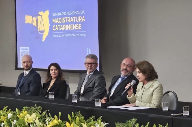 Foto horizontal: autoridades participam de mesa de debates durante o Seminário Regional da Magistratura Catarinense. Ao centro, o desembargador Dinart Francisco Machado acompanha a fala da desembargadora Vera Lúcia Ferreira Copetti.
