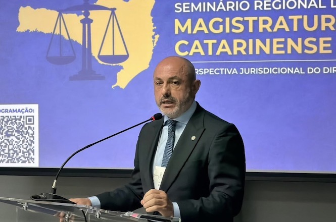 Foto horizontal: desembargador André Luiz Dacol profere palestra durante seminário da magistratura catarinense, diante de painel temático sobre Direito.