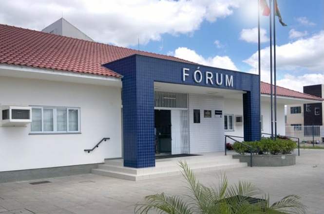 Foto horizontal: fachada do fórum de Camboriú, prédio institucional com entrada em destaque, ambiente externo, clima de acesso à Justiça.