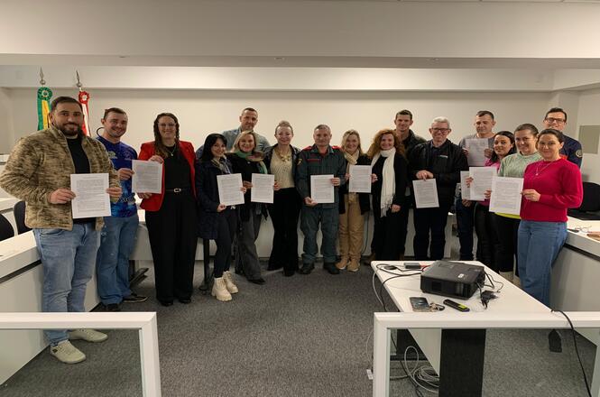 Foto horizontal: participantes exibem certificados durante solenidade na comarca de Campo Erê.