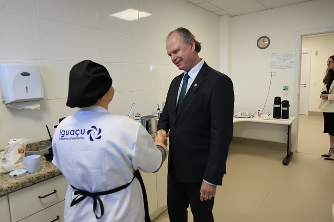 Foto horizontal: presidente do TJSC, desembargador Rubens Schulz, cumprimenta trabalhadora durante visita às instalações do Fórum.