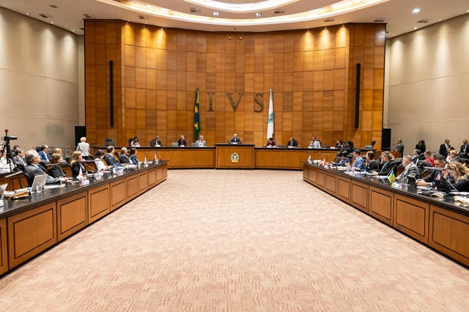 Foto horizontal: sessão plenária em auditório institucional, autoridades reunidas em formato colegiado, clima de deliberação e cooperação entre estados.