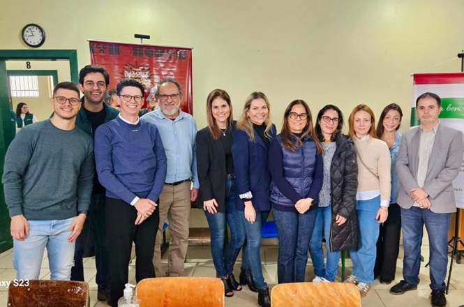 Foto horizontal: grupo de participantes e autoridades posa em atividade na Terra Indígena Laklãnõ, registro coletivo em ambiente comunitário, clima de integração, diálogo e ação social.