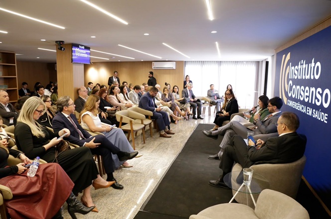 Foto horizontal: participantes acompanham debate em painel durante evento do Instituto Consenso, em ambiente com público reunido.