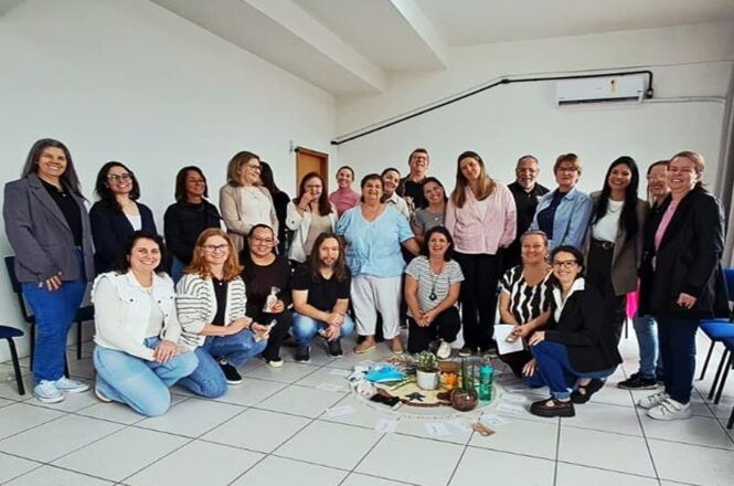 Foto horizontal: grupo reunido ao final de encontro voltado à troca de experiências e aprendizado.