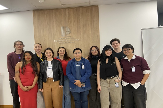 Foto horizontal: grupo de visitantes posa após visita à exposição comemorativa dos 135 anos do TJSC.
