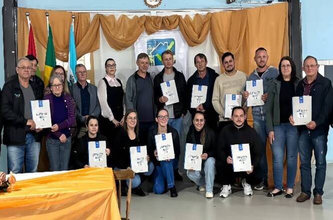 Moradores exibem títulos de propriedade durante entrega de documentos do Programa Lar Legal