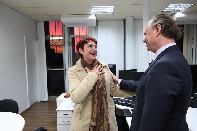 Foto horizontal: presidente do TJSC, desembargador Rubens Schulz, conversa de forma descontraída com servidora sorridente durante visita a setor de trabalho.