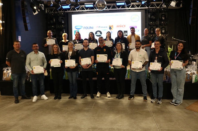 Foto horizontal: representantes de empresas parceiras do Novos Caminhos posam com certificados durante evento no Alto Vale.