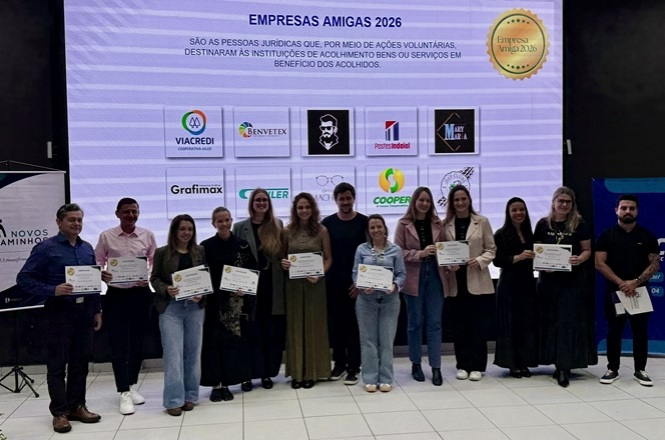 Foto horizontal: representantes de Empresas Amigas 2026 do Novos Caminhos posam com certificados durante evento em Blumenau.