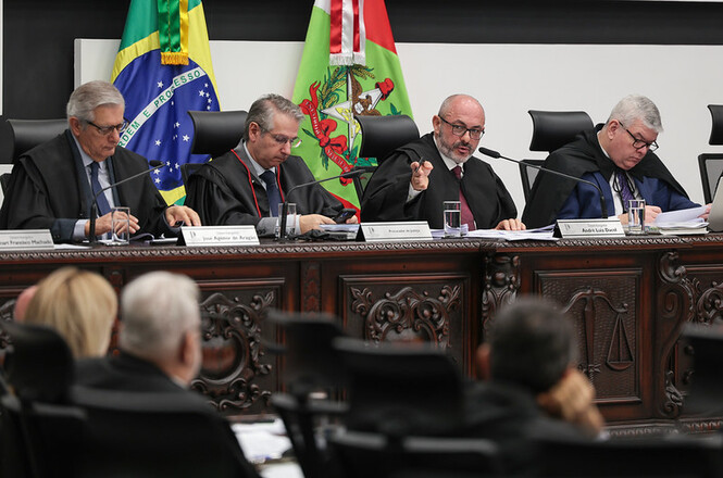 Foto horizontal: presidente do TJSC, des. André Luiz Dacol, fala ao microfone durante sessão, acompanhado de magistrados.