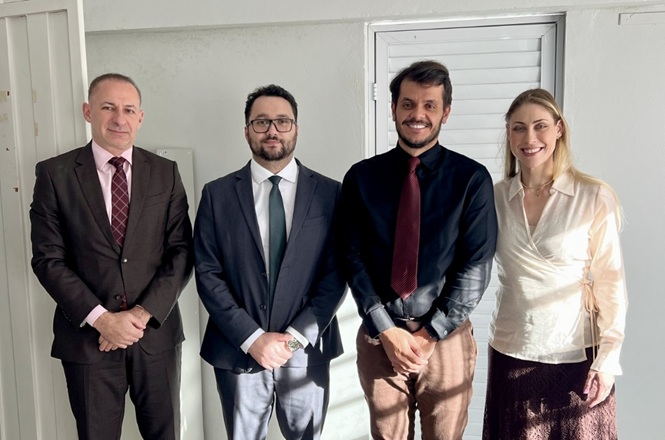 Foto horizontal: autoridades e participantes da Semana da Pauta Verde posam para registro em ambiente institucional iluminado pela luz natural.