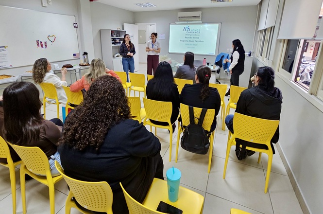 Foto horizontal: Participantes acompanham encontro de acolhimento do Programa Novos Caminhos em ambiente de capacitação.