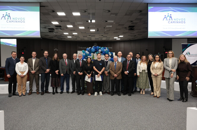Foto horizontal: grupo de autoridades, representantes e jovens posa para foto durante evento do programa Novos Caminhos no plenário do TJSC.