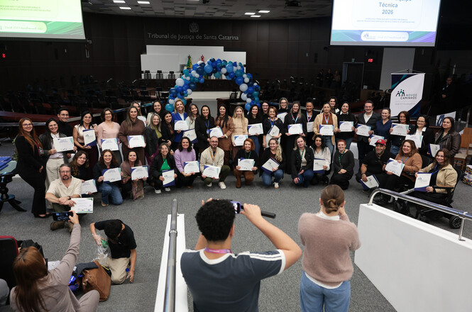 Foto horizontal: participantes do programa Novos Caminhos posam com certificados durante evento no plenário do TJSC.