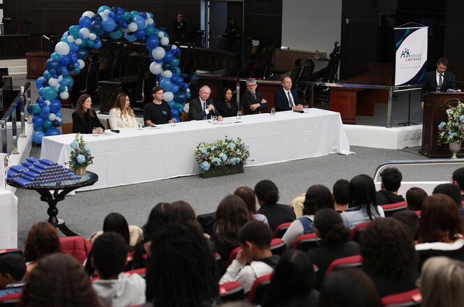 Foto horizontal: autoridades e representantes do programa Novos Caminhos compõem a mesa de cerimônia, diante do público no plenário do TJSC.