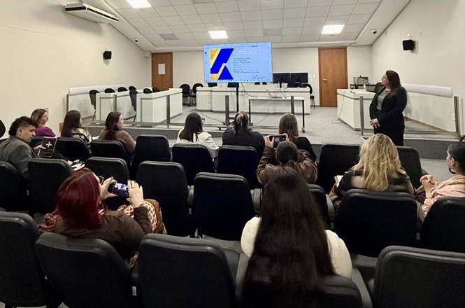Foto horizontal: Participantes acompanham apresentação sobre o Programa Novos Caminhos em auditório do Poder Judiciário.