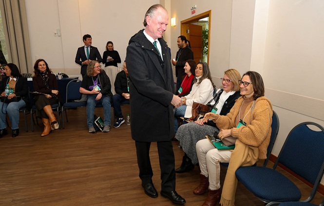 Foto horizontal: o presidente do TJSC, desembargador Rubens Schulz, cumprimenta participantes durante solenidade de aposentadoria, em momento de acolhimento e confraternização com magistrados, servidores e convidados.
