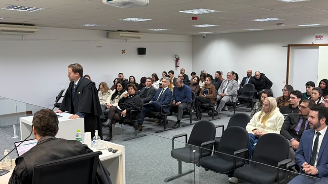 Foto horizontal: advogado faz sustentação oral diante do público durante sessão de julgamento.
