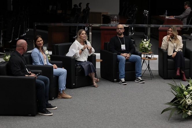 Foto colorida: participantes em painel de debates, plenário do TJSC, evento sobre saúde mental, discutindo temas em preto, branco e cinza
