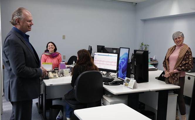 Foto horizontal: presidente do TJSC, desembargador Rubens Schulz, conversa com servidoras durante visita a um setor de trabalho.