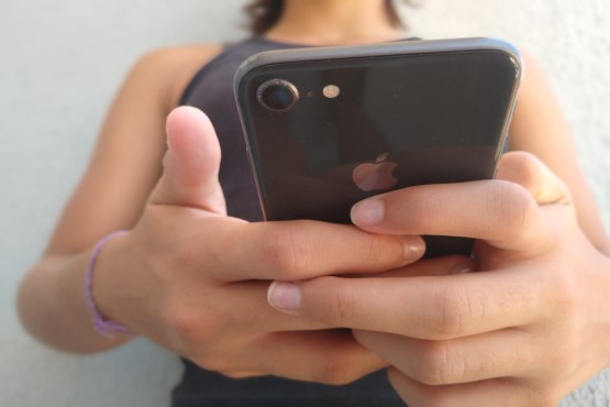 Mulher com celular nas mãos.