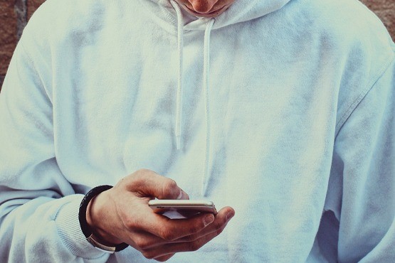 Homem segurando celular.