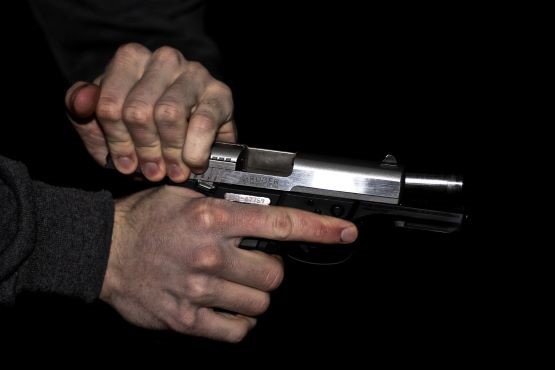 Imagem ilustrativa de homem segurando arma.
