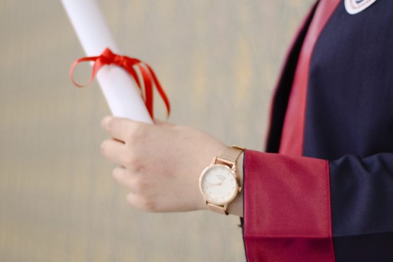 Mão segurando diploma.