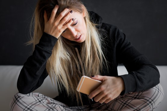 Mulher segurando celular.