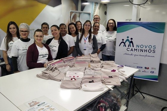 Alunas da escola Móvel do Senai e as nécessaires produzidas por elas.