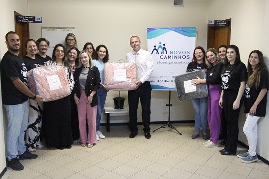 Voluntários e parceiros do projeto Novos Caminhos em entrega de cobertores.