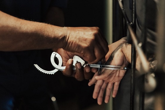 Homem retirando algemas de preso.