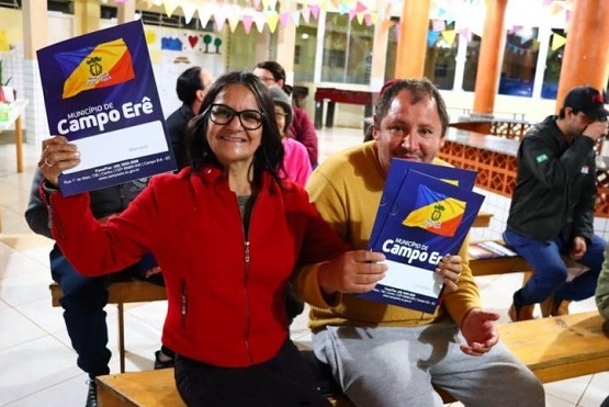 Família recebe escritura de sua casa.